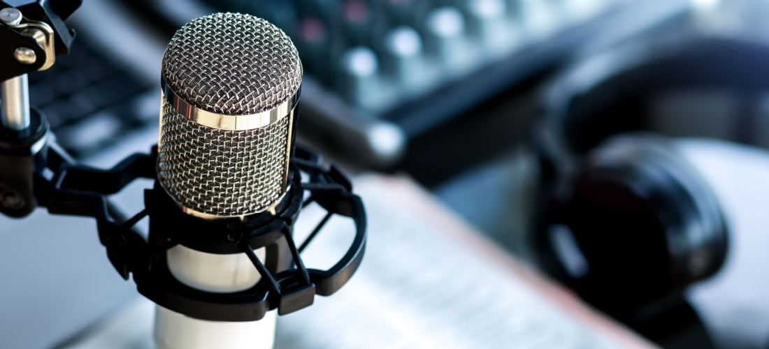 Micrófono de radio con auriculares de diadema y libro.